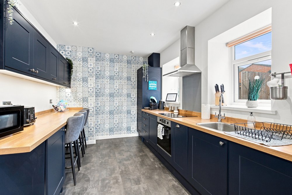 Large galley kitchen with navy cabinetry