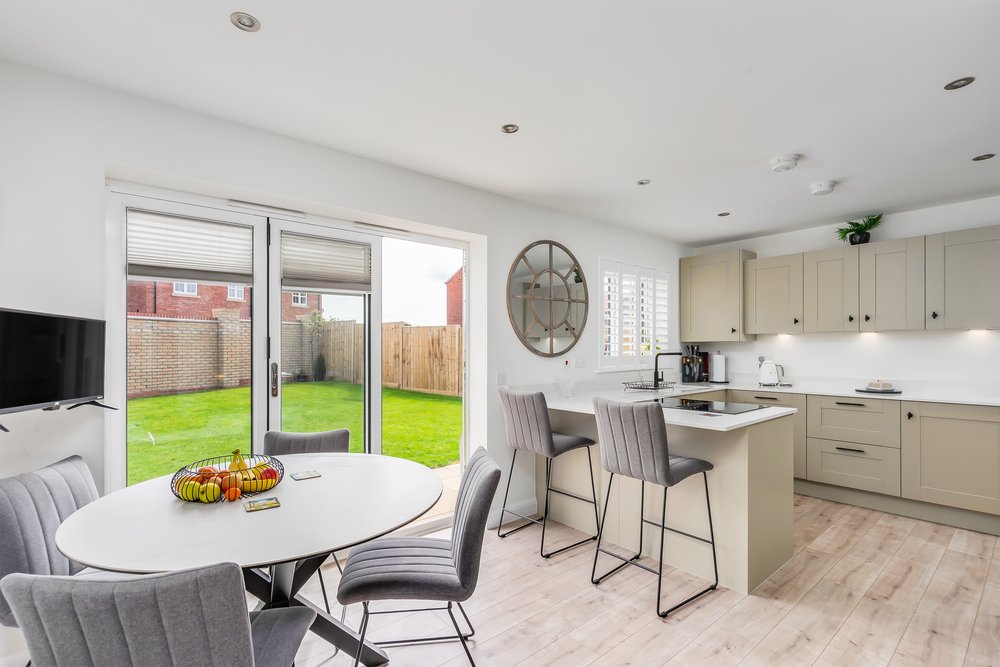 Modern kitchen diner with bifold doors opening onto the garden
